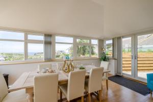 a dining room with a table and chairs and windows at 3 Bed in Tintagel oc-a36172 in Tintagel