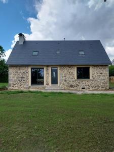a stone house with a gray roof at Gîte Le Valeix in Neuvic