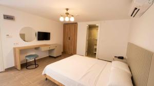a bedroom with a bed and a desk and a television at Icarus Alaçatı in Çeşme