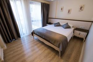 a bedroom with a bed and a large window at Icarus Alaçatı in Çeşme