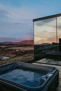 a bath tub with a view of the desert at ÖÖD Hekla Horizon - Mirror Houses in Hella