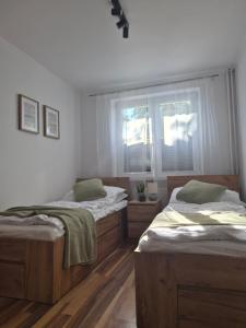 a bedroom with two beds and a window at Apartament przy Dworcu Sanok in Sanok