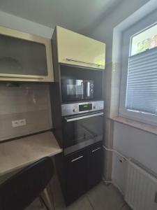 a small kitchen with a microwave oven and a window at Apartament przy Dworcu Sanok in Sanok