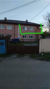 a green arrow on a fence in front of a house at Apartment near Corvin Castle in Hunedoara