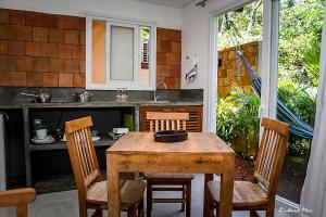 cocina con mesa de madera con sillas y fregadero en Jardim Secreto, en Morro de São Paulo