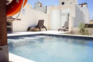 a swimming pool in a yard with two chairs at Staytopus Kenn is Sur - Citadel Victoria Gozo Hideaway - Pool in Victoria