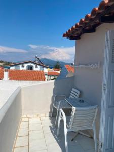 a patio with a table and chairs on a balcony at Blue Street Apartments in Pythagoreio