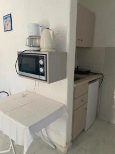a kitchen with a microwave on top of a table at Blue Street Apartments in Pythagoreio
