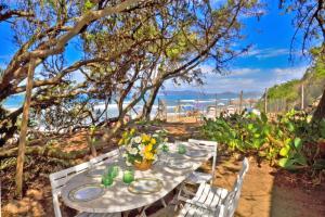 a table with plates and flowers on the beach at Casa Giannellina - Happy Rentals in Orbetello