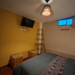 a bedroom with a bed and a television and a ladder at Sunshine in Ollantaytambo