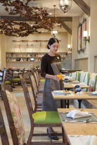 a woman standing in a dining room with tables at U Khao Yai in Mu Si