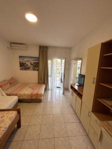 a hotel room with two beds and a television at Apartmani Miladinović in Sutomore