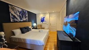 a bedroom with a large white bed and a tv at LÚA Cies Room in Oya