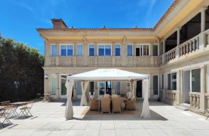 a white umbrella on a patio in front of a house at Ocean View Room Oia in Oya