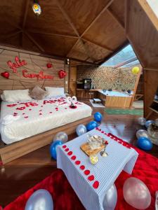 a bedroom with a bed with balloons and a table at Imperios Glamping in Silvania +10 photos