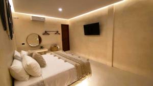 a bedroom with a bed and a tv on the wall at Ananda Hotel Boutique in Holbox Island +29 photos
