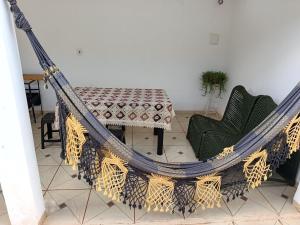 a hammock in a room with a table and chairs at Pedacinho do céu 2 in Dourados