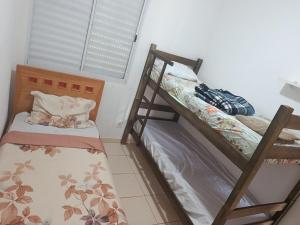 two bunk beds in a room with a window at Pedacinho do céu 2 in Dourados