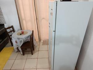a kitchen with a refrigerator and a table with a candle at Pedacinho do céu 2 in Dourados