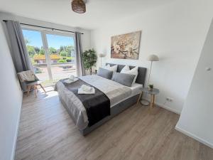 a bedroom with a bed and a large window at RegioStyle Gemütliche Wohnung im Schaalseepark! in Zarrentin