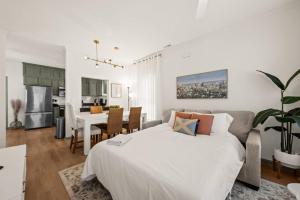 a bedroom with a white bed and a dining room at Charleston 3BR Home · 3 Baths · Porches · Dogs OK in Charleston