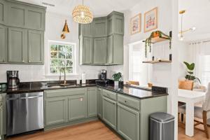 a kitchen with green cabinets and black counter tops at Charleston 3BR Home · 3 Baths · Porches · Dogs OK in Charleston +27 photos