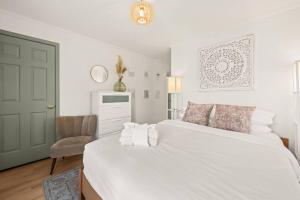 a bedroom with two white beds and a chair at Charleston 3BR Home · 3 Baths · Porches · Dogs OK in Charleston