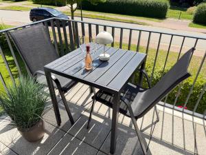 a wooden table with a bottle of beer and a chair at RegioStyle Gemütliche Wohnung im Schaalseepark! in Zarrentin