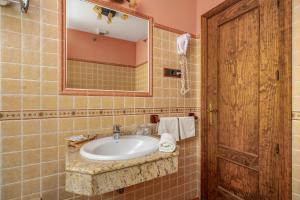 a bathroom with a sink and a mirror at Hotel Balcón de los Montes in Colmenar +94 photos