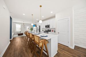 a kitchen with white cabinets and a table with chairs at Sweetgrass Row at Cane Bay in Summerville