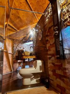 a bathroom with a toilet in a brick wall at Imperios Glamping in Silvania