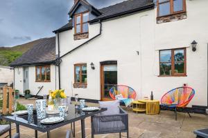 a patio with a table and chairs in front of a house at Lovely 2 Bedroom Countryside Retreat in Shelve