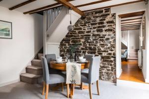 a dining room with a stone wall and a table and chairs at Lovely 2 Bedroom Countryside Retreat in Shelve