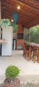 a patio with a picnic table and a refrigerator at Chalé Cogumelo Refugio dos Gnomos in Visconde De Maua