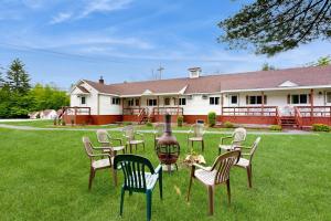 a group of chairs and a grill in the yard of a house at Charming and casual motel in a great location with shared resort amenities in Lincoln