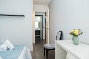 a bedroom with a bed and a table with a vase of flowers at Canhas Ocean View in Ponta do Sol