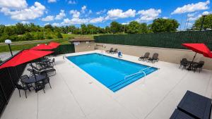 a swimming pool with tables and chairs and umbrellas at Hotel Lotus Kansas City Stadium in Kansas City