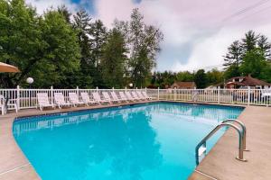 a large swimming pool with chairs and a white fence at Charming and casual motel in a great location with shared resort amenities in Lincoln