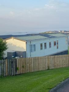 a blue house behind a wooden fence at Angie Bs Beach Haven in Groomsport