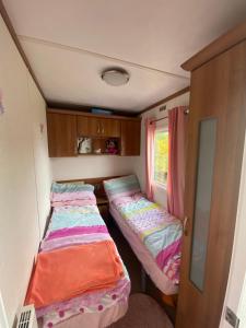 a small room with two beds in a caravan at Angie Bs Beach Haven in Groomsport
