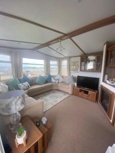 a living room with a couch and a tv at Angie Bs Beach Haven in Groomsport