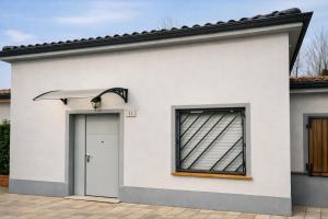 a white house with a door and a window at Lary&Giù in Cadelbosco di Sopra