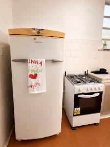 a white refrigerator in a kitchen next to a stove at Apartamento em Botafogo 5 min de Copacabana in Rio de Janeiro