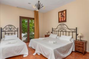 a bedroom with two beds with white sheets at Hotel Balcón de los Montes in Colmenar