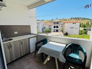 a kitchen with a table and chairs on a balcony at Apartmani Miladinović in Sutomore