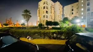a person sitting on the ground in front of a car at شقق قرية النورس in Ismailia