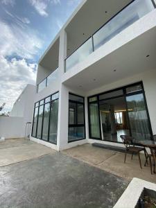 a white house with glass windows and a table at الدغيثر للشقق المخدومه in Ash Shafa