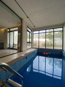 a swimming pool in a house with blue tiles at الدغيثر للشقق المخدومه in Ash Shafa