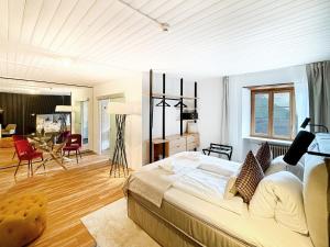 a bedroom with a large bed and a living room at DU GLACIER Boutique & Traditions Hotel in Fiesch