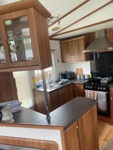 a kitchen with wooden cabinets and a counter top at Angie Bs Beach Haven in Groomsport